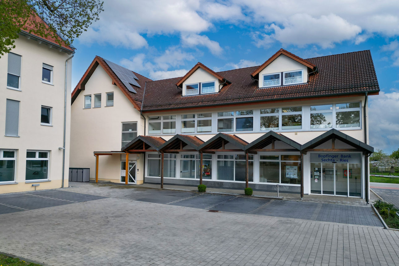 Luftaufnahme von einem Bankgebäude mit Parkplätzen davor