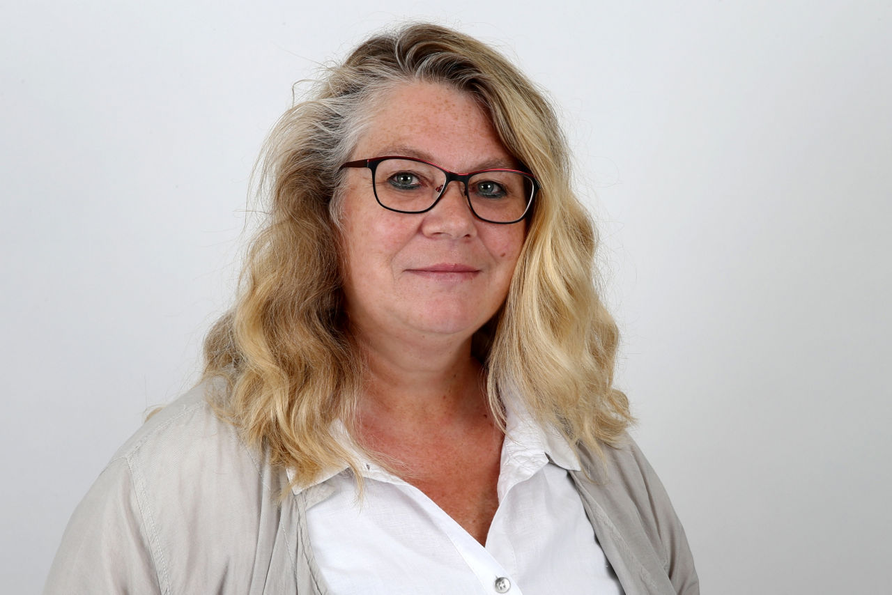 Eine lächelnder Frau schaut in die Kamera.