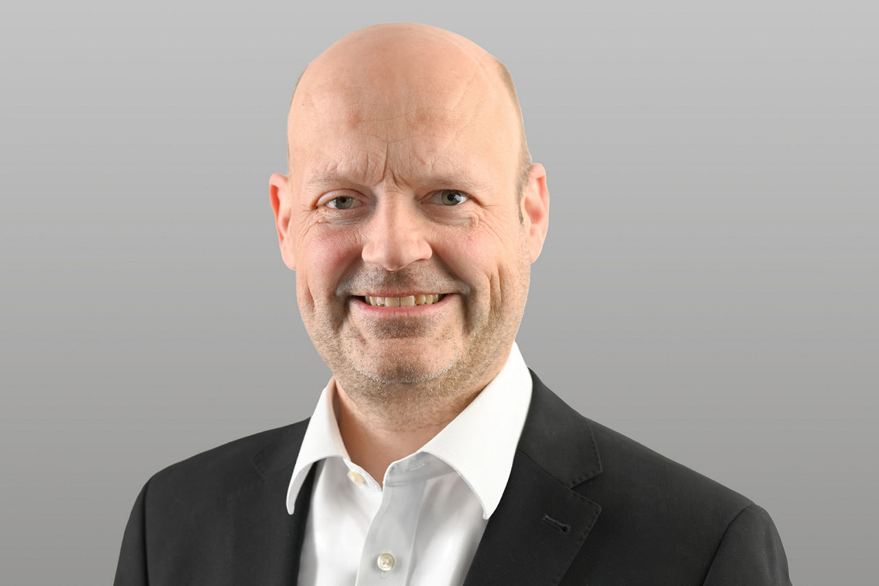 Firmenkunden Eric Brühne vor grauem Hintergrund