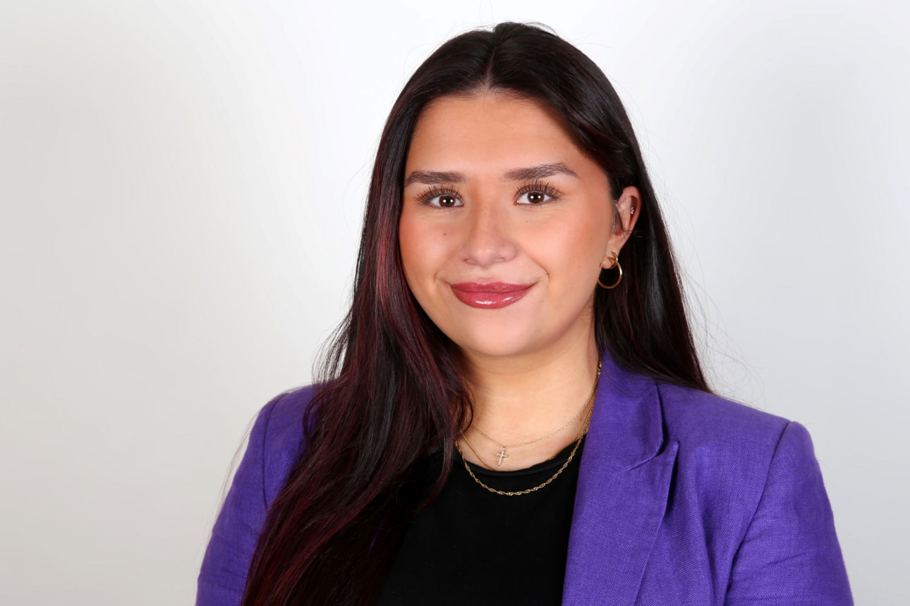 Eine lächelnde Frau schaut in die Kamera.