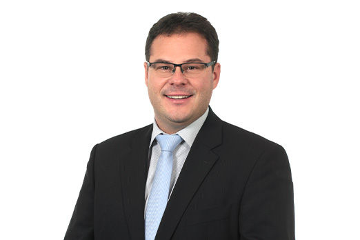 Freundlich lächelnder Mann im Anzug, unser Geschäftsstellenleiter Kumhausen Klaus Brauner