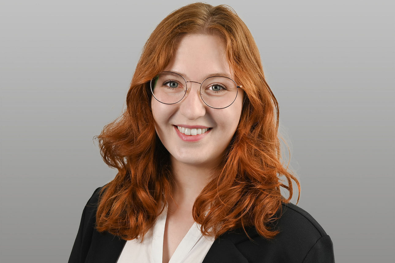 Servicemitarbeiterin Johanna Breithaupt vor grauen Hintergrund