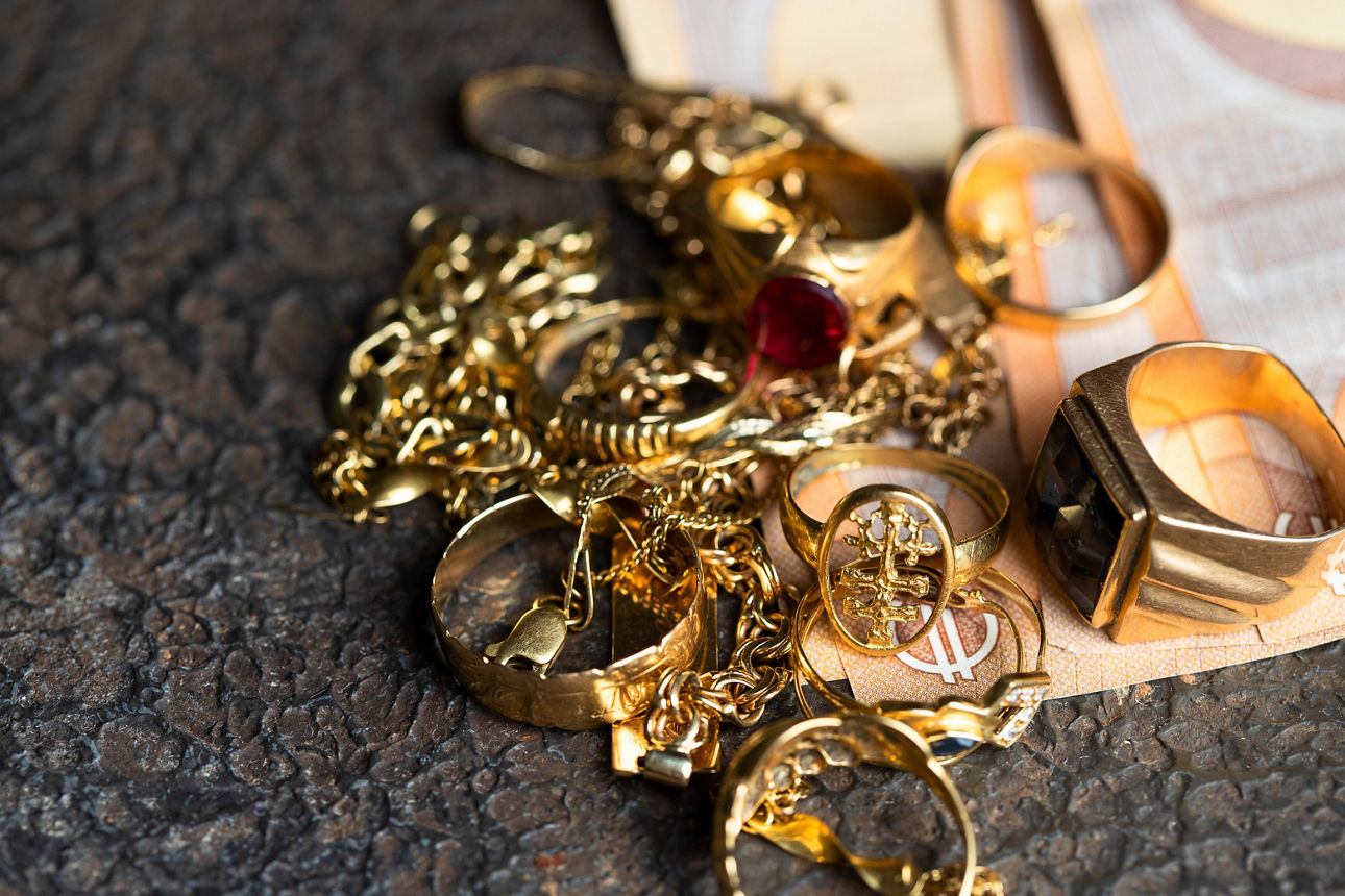 Old and broken jewelry  and on Euro banknotes on dark background. Sell gold for money  concept.
