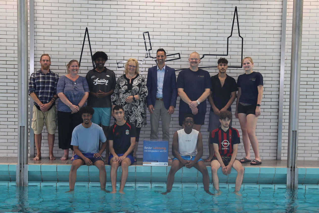 Gruppenbild Betreuer der Brücken-Stfiftung, Schwimmtrainerteam, Vorstand Peter Schau und den Teilnehmern des Schwimmkurses