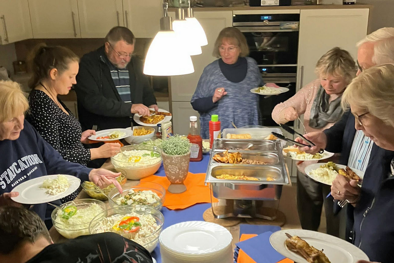 Einen Teil der Nachbarschaftsgruppe stehend am Buffet