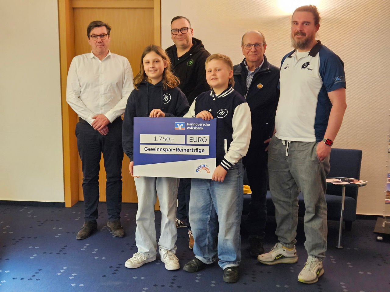 4 Männer und Kinder, welche ein Schild hochhalten.