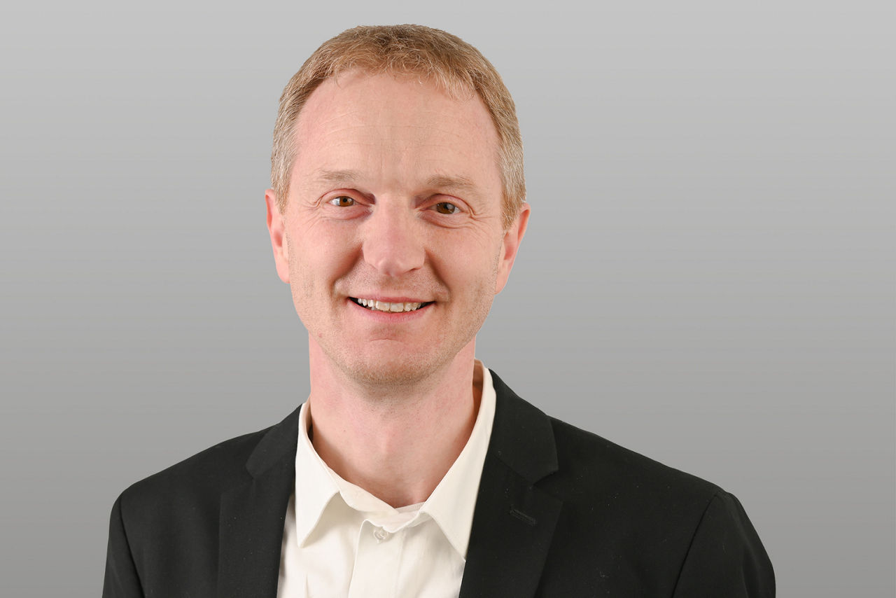 Privatkundenberater Jens Burghoff vor grauen Hintergrund