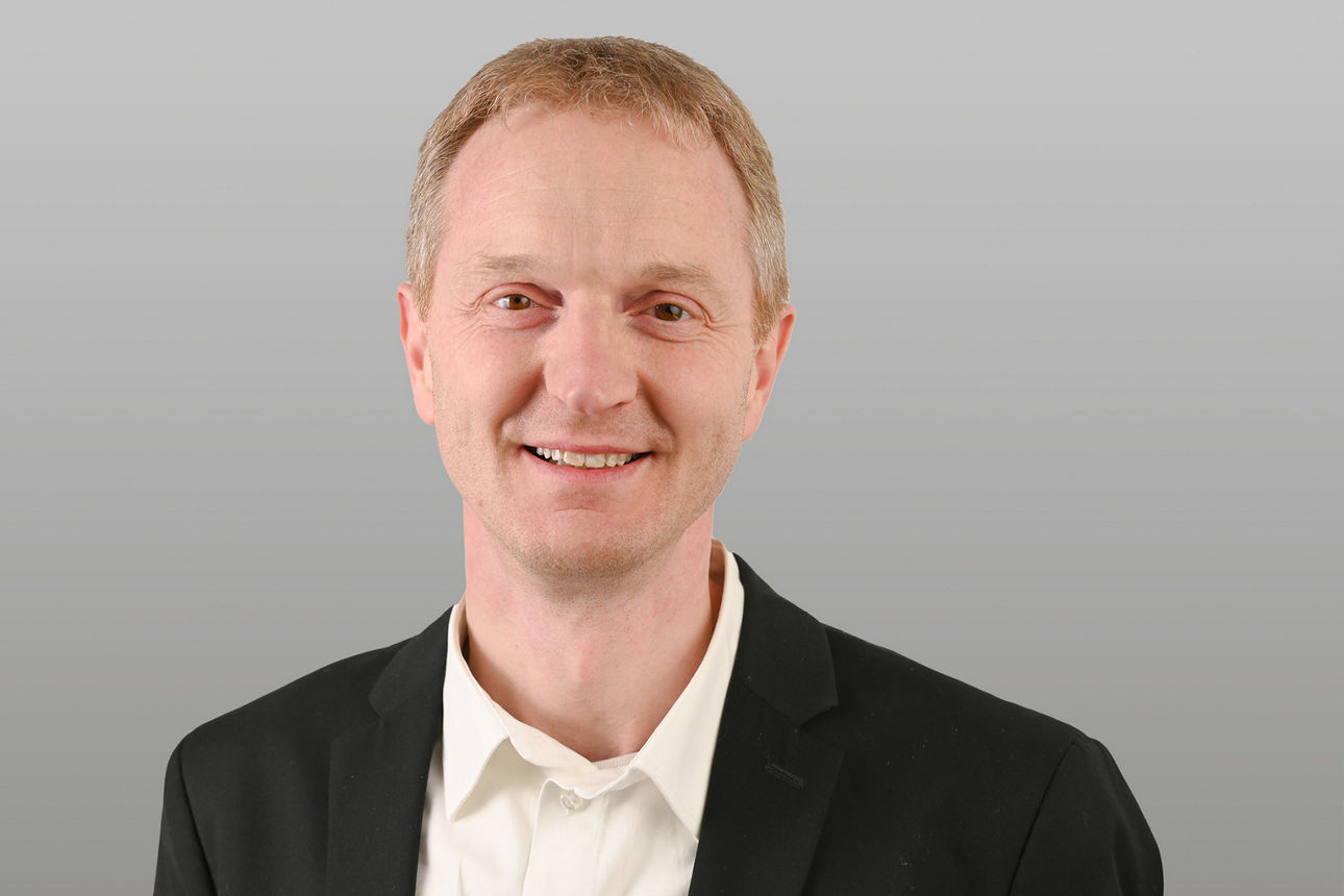 Privatkundenberater Jens Burghoff vor grauen Hintergrund