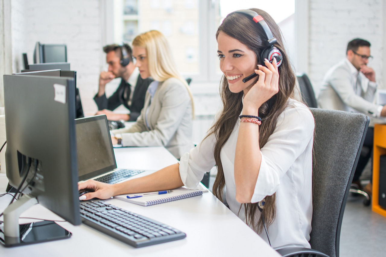 Mitarbeiter eines Callcenters vor dem Bildschirm