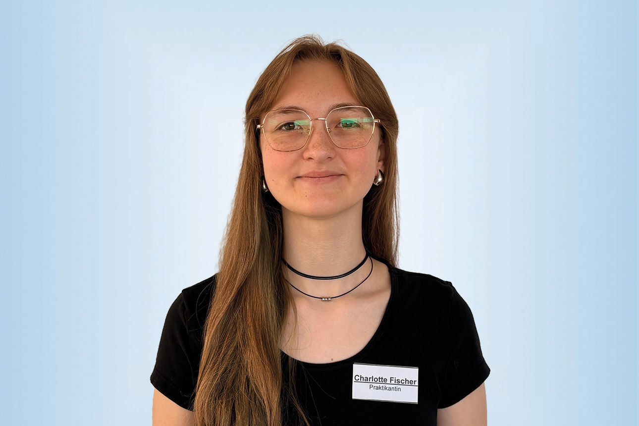 Praktikantin Charlotte Fischer vor einem blauen Hintergrund