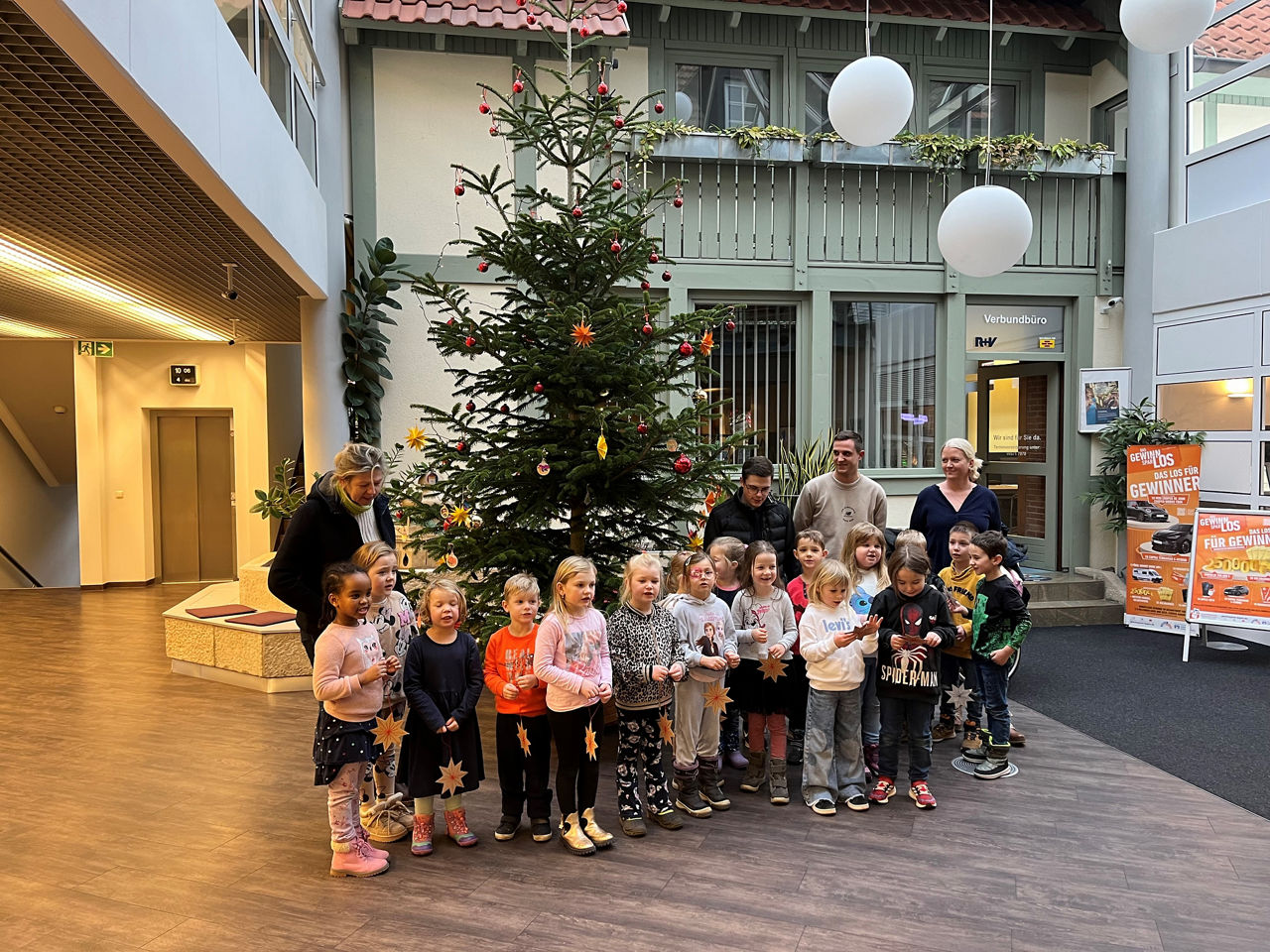 Kindergartenkinder vom städt. Kindergarten Ebern schmücken den Christbaum in der Bank
