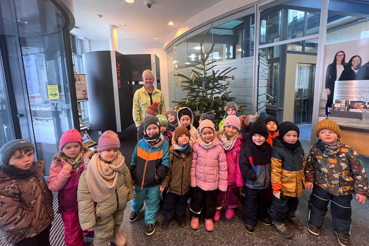 Kindergartenkinder vor dem geschmückten Christbaum in Hardt