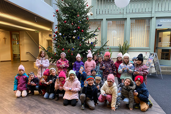 Kindergartenkinder schmücken die Christbäume in unseren Schalterhallen