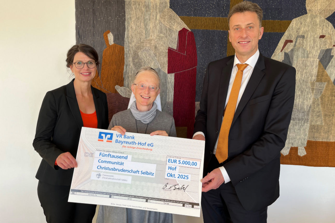 Drei Personen halten den Spendencheck in den Händen