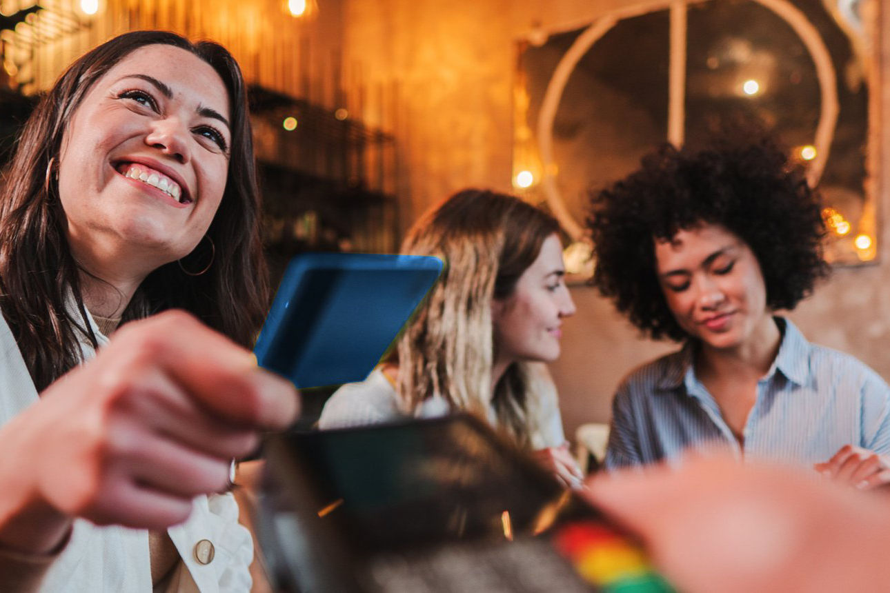 Zwei Frauen zahlen im Restaurant mit Karte