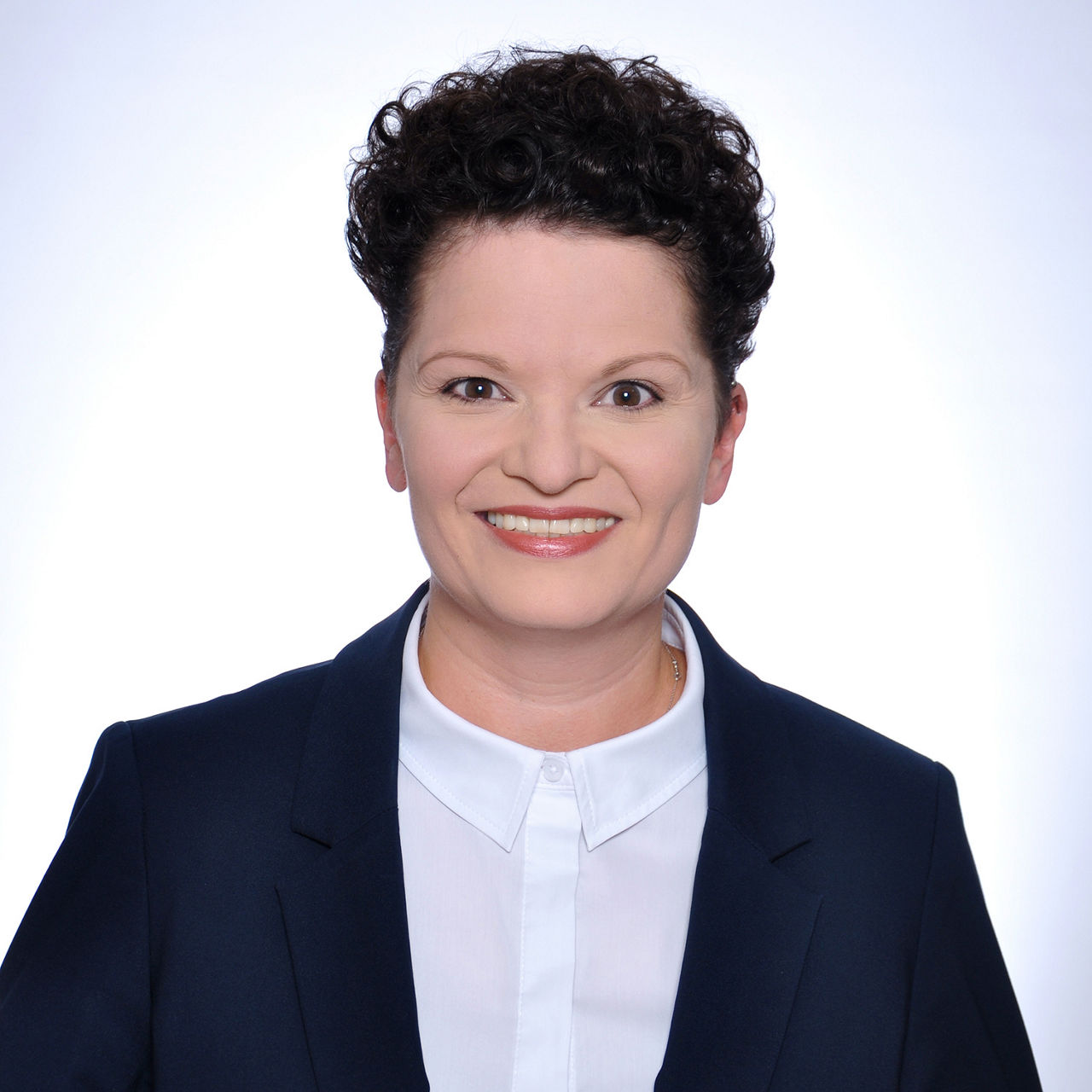 Foto unserer Vermögensberaterin Claudia Bosch vor einem weißen Hintergrund in einem schwarzen Blazer