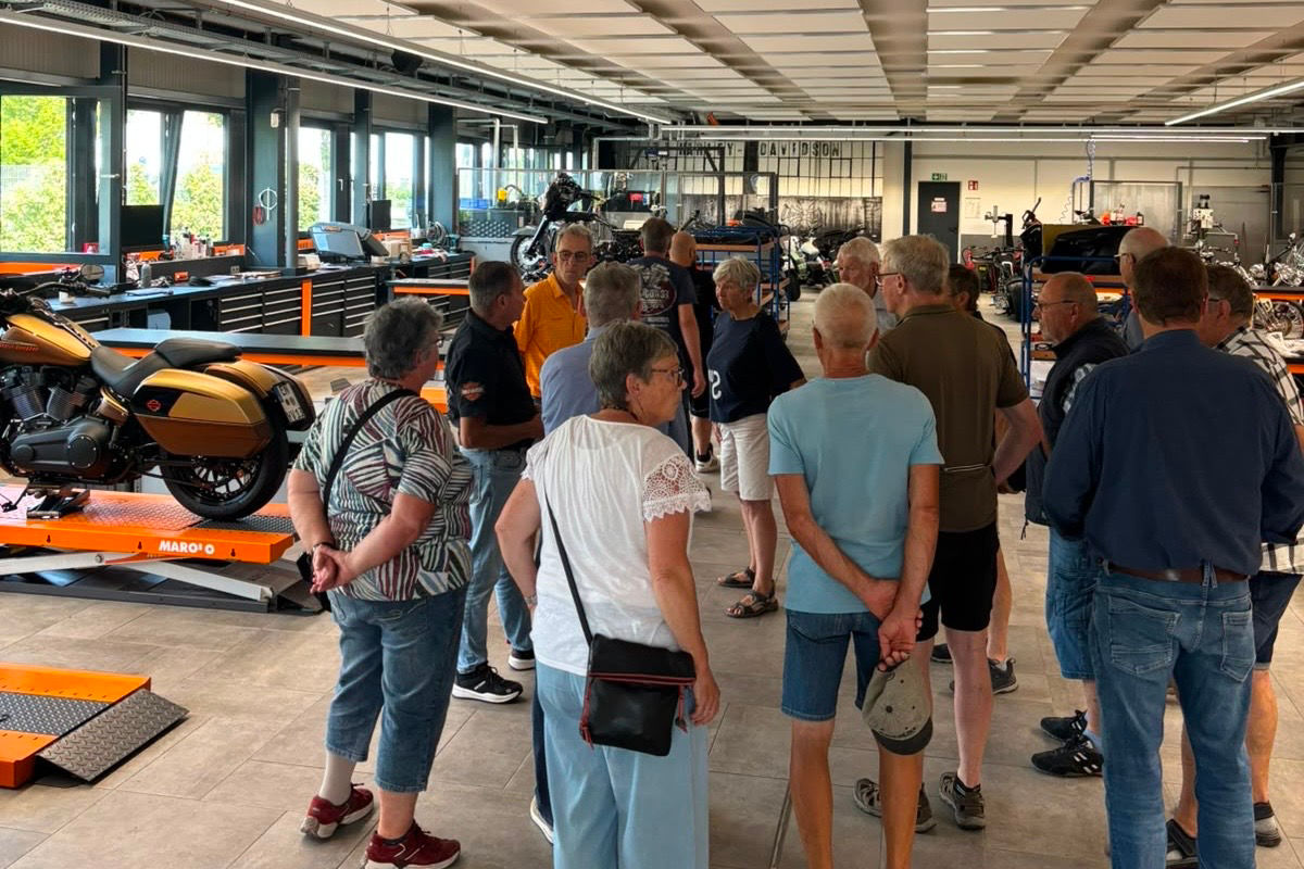 Eine Gruppe von Menschen stehen im Ausstellungsraum von Harley Davidson