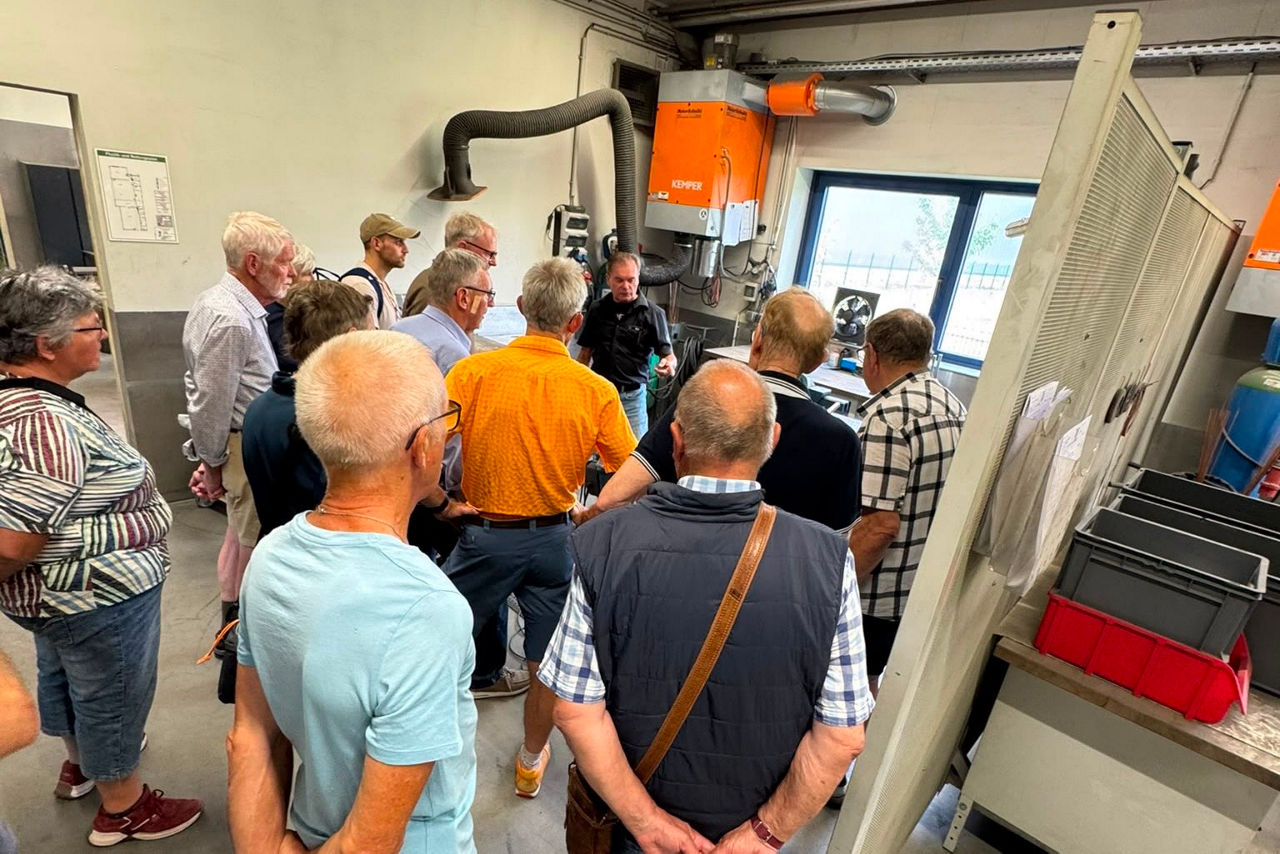 Eine Gruppe von Menschen steht in der Werkstatt von Harley Davidson in Hamminkeln