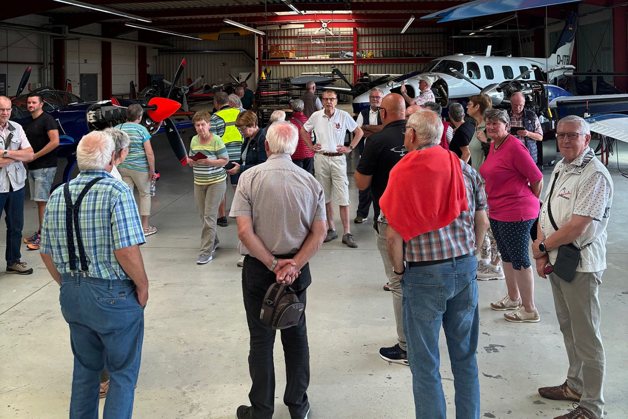 Menschen stehen in einem Hanger