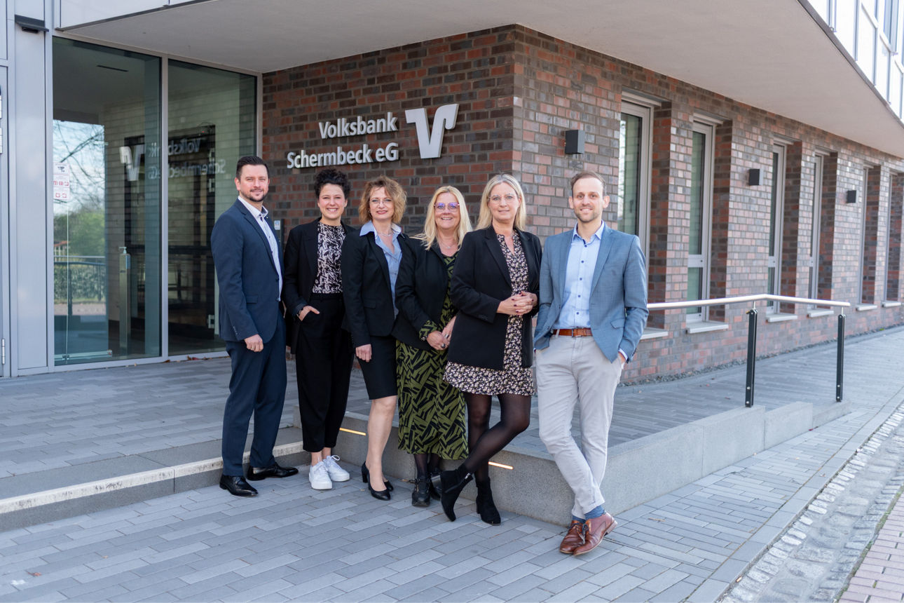 Eine Gruppe von Personen stehend vor der Bank