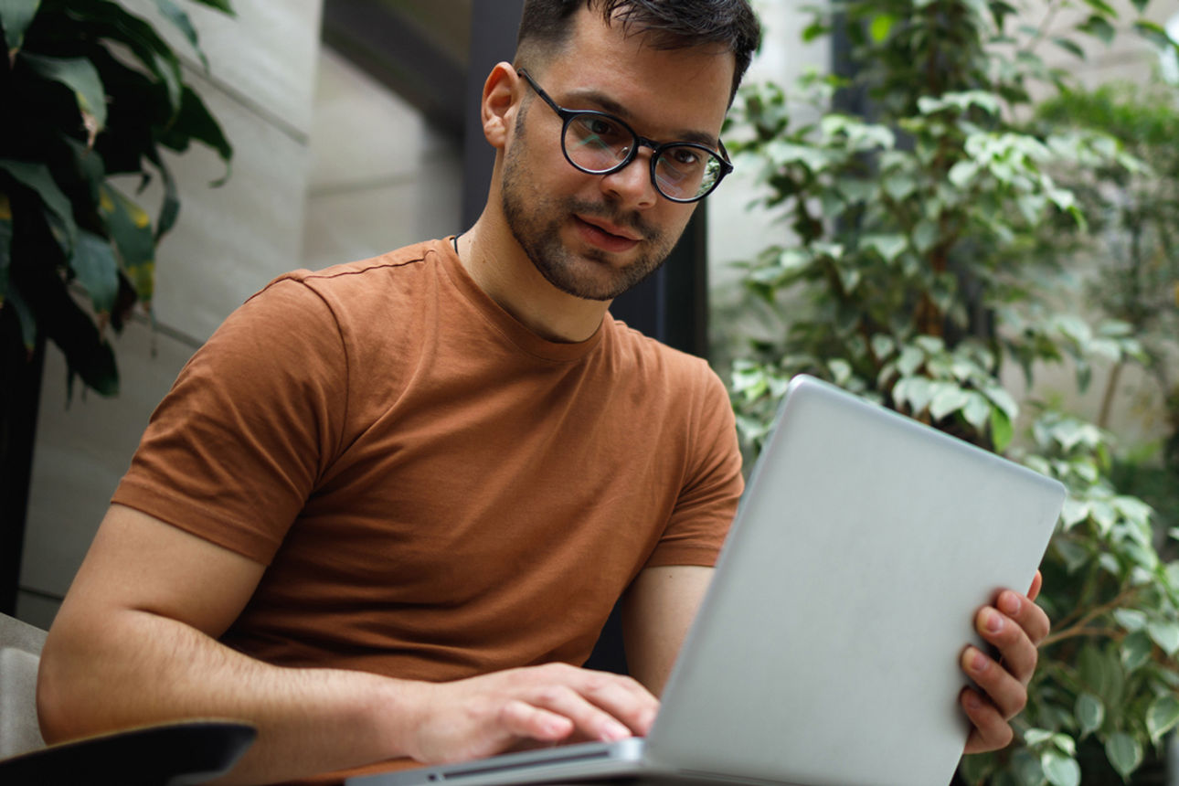 Junger Mann beim Arbeiten am Laptop