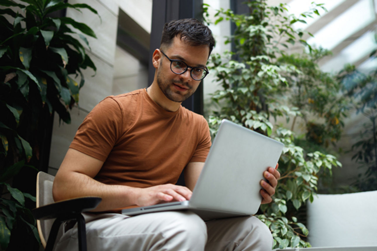 Junger Mann beim Arbeiten am Laptop