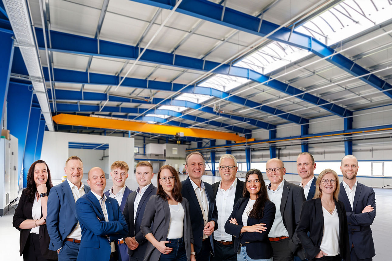 Eine Gruppe von Geschäftsleuten, die zusammen in einem geräumigen Lagerhaus stehen.