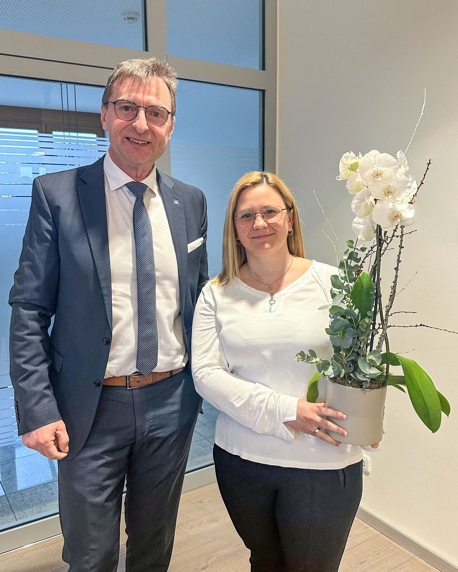 Ein Mann steht neben einer Frau, die eine Orchidee in der hand hält
