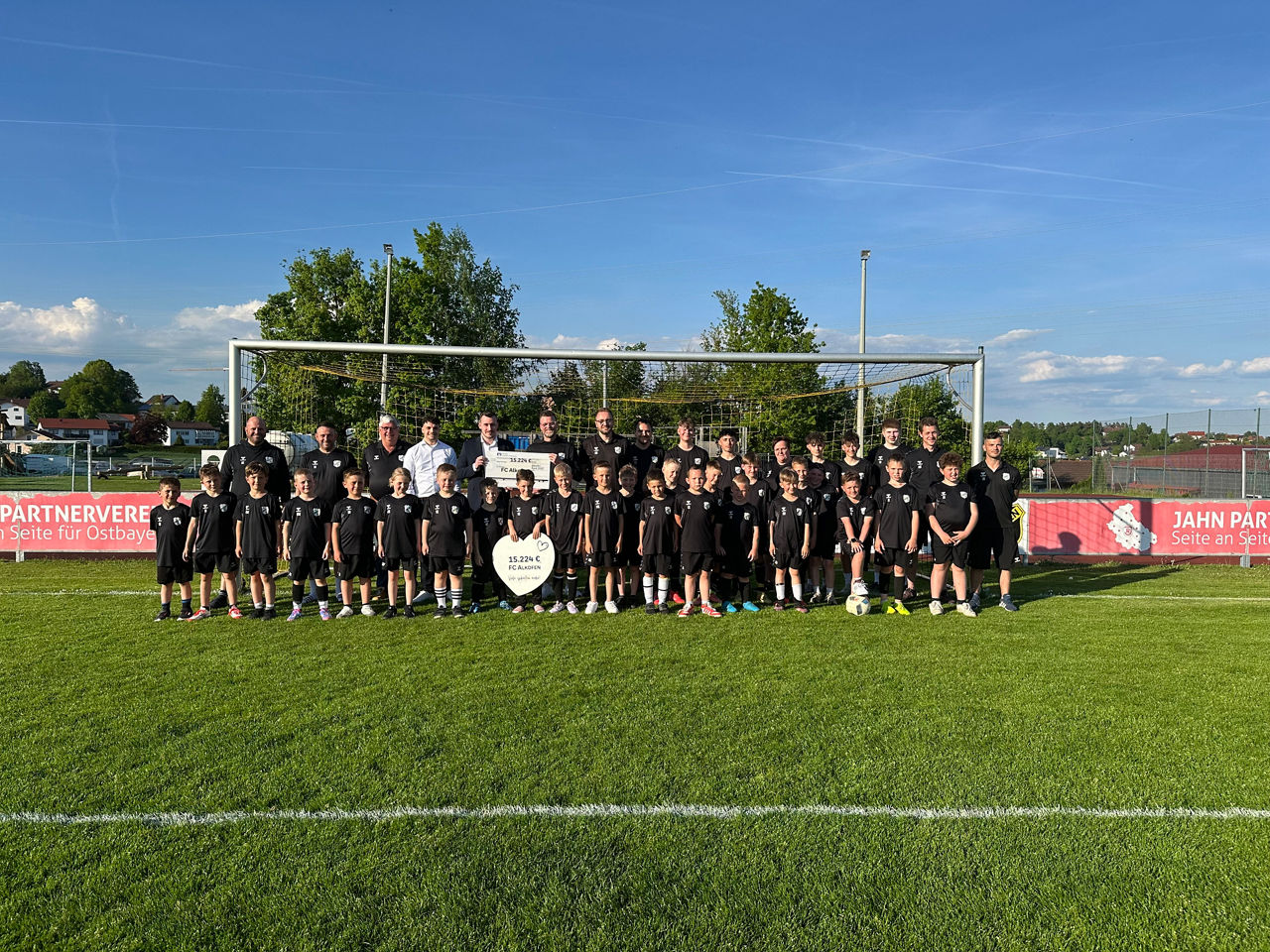 FC Alkofen mit Mitarbeitern der Bank und einem Spendenscheck