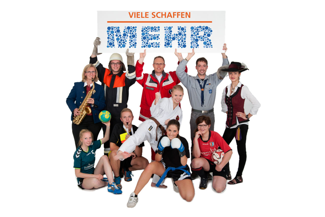 Personengruppe mit unterschiedlichen Vereinsmitgliedern halten ein „Viele schaffen mehr“-Logo in die Höhe