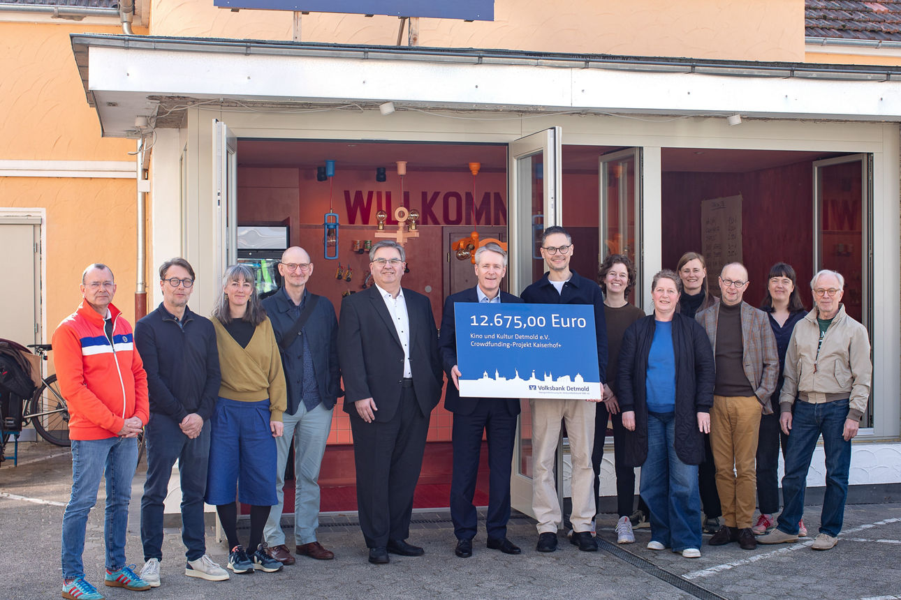 Das Team vom Verein Kino und Kultur Detmold und Vertreter der VerbundVolksbank OWL eG halten einen Spendenscheck in den Händen. 