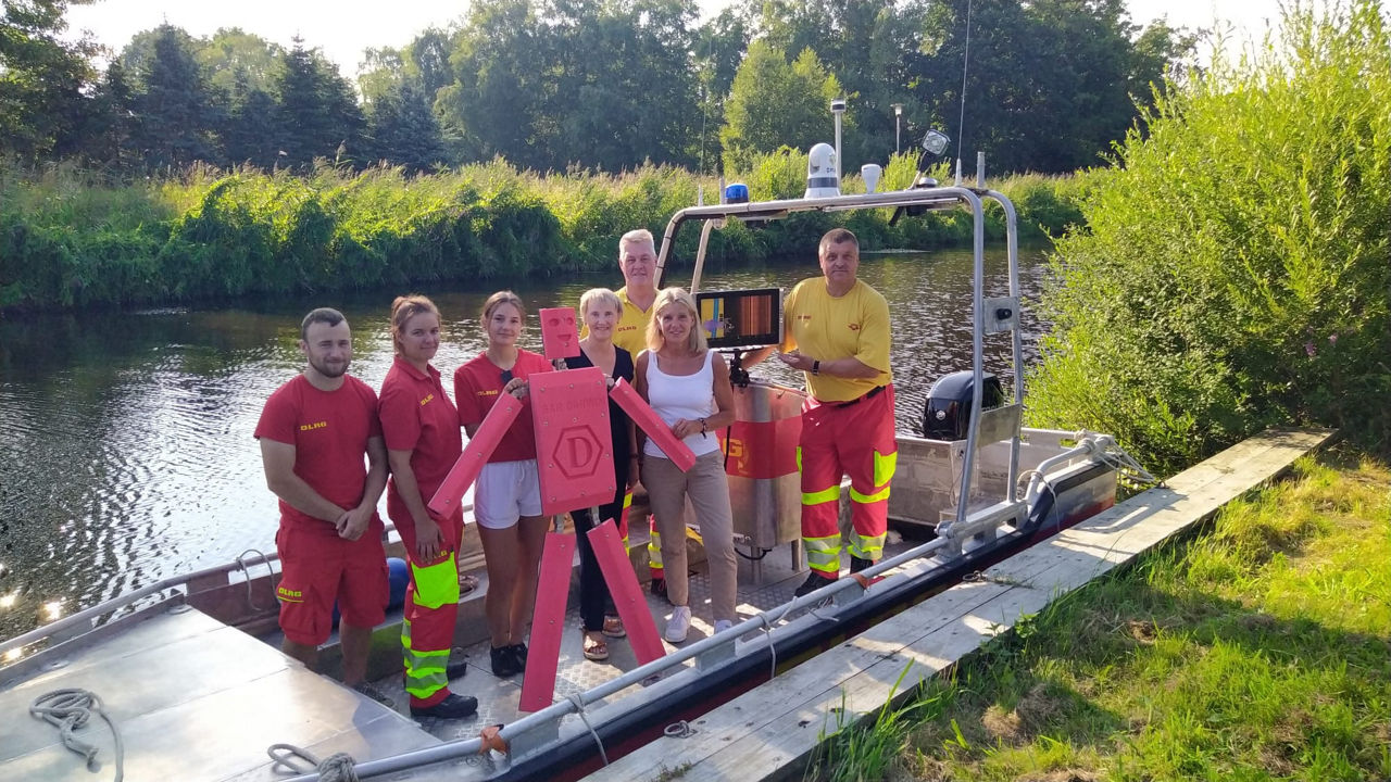 Gruppenbild der DLRG Ortsgruppe Bederkesa mit dem Echolot auf einem Motorboot