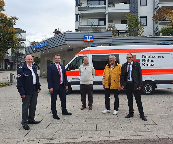 Vier Männer stehen vor einem weißen Krankenwagen