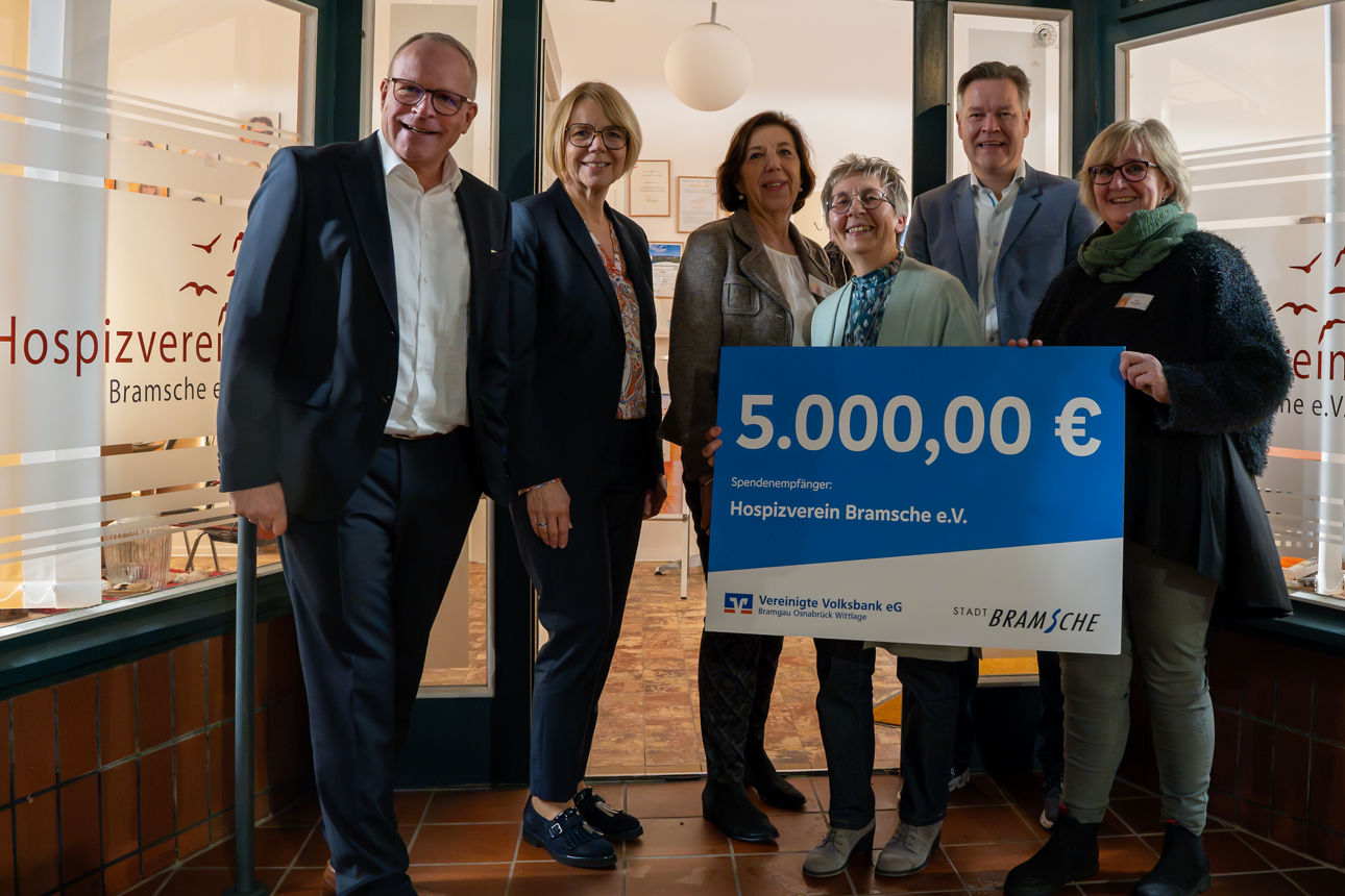 6 Personen halten einen Scheck über die Spende von 5000€ vor sich