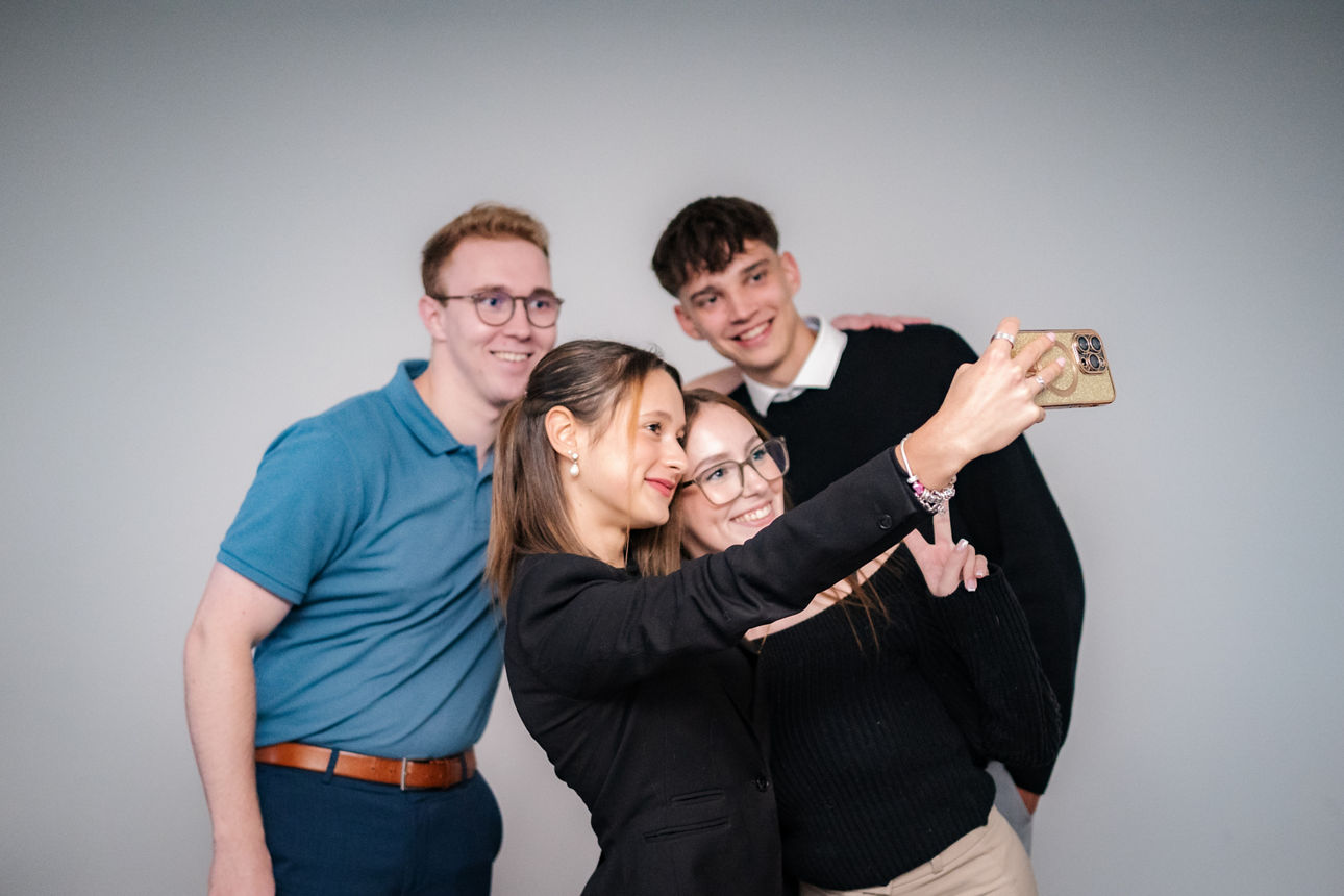 Zwei Männer und zwei Frauen machen gemeinsam ein Selfie