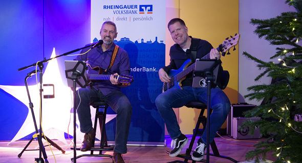 Sie halten Musikinstrumente in der Hand und blicken in die Kamera