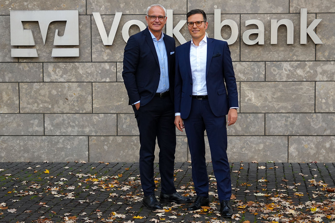 Olaf Kothes, links und Christoph Gommans, rechts stehen vor der  Volksbank