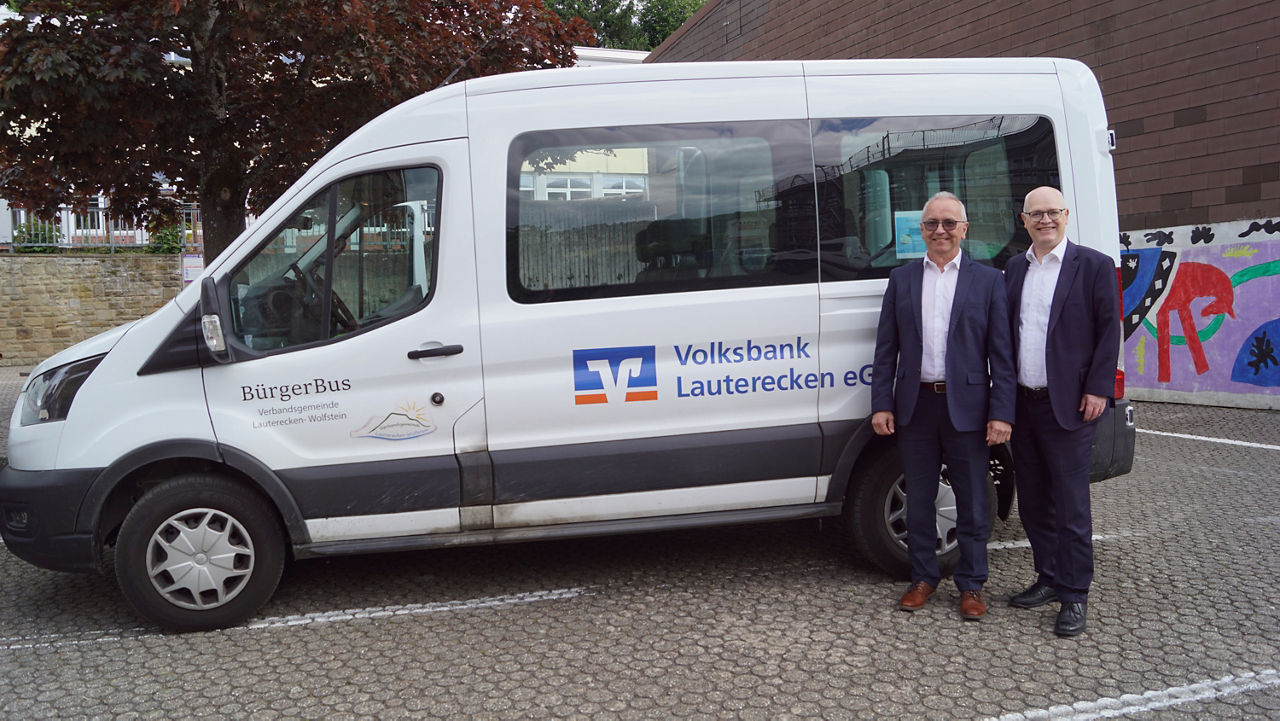 Zwei Vertreter stehen neben dem neuen „BürgerBus“-Kleinbus, gesponsert von der Volksbank Lauterecken eG.