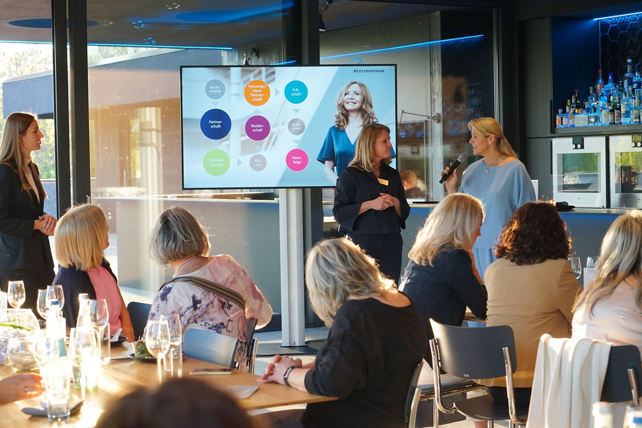 Vier Personen stehen nebeneinander und halten gemeinsam einen gerahmten Text mit Auszeichnung