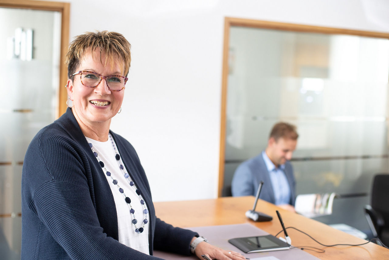 Mitarbeiterin der Volksbank Schermbeck lächelnd an ihrem Arbeitsplatz