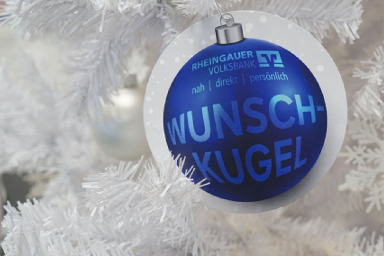 Eine Weihnachtsbaumkugel auf einem weißen Weihnachtsbaum mit der Aufschrift "Wunschkugel"