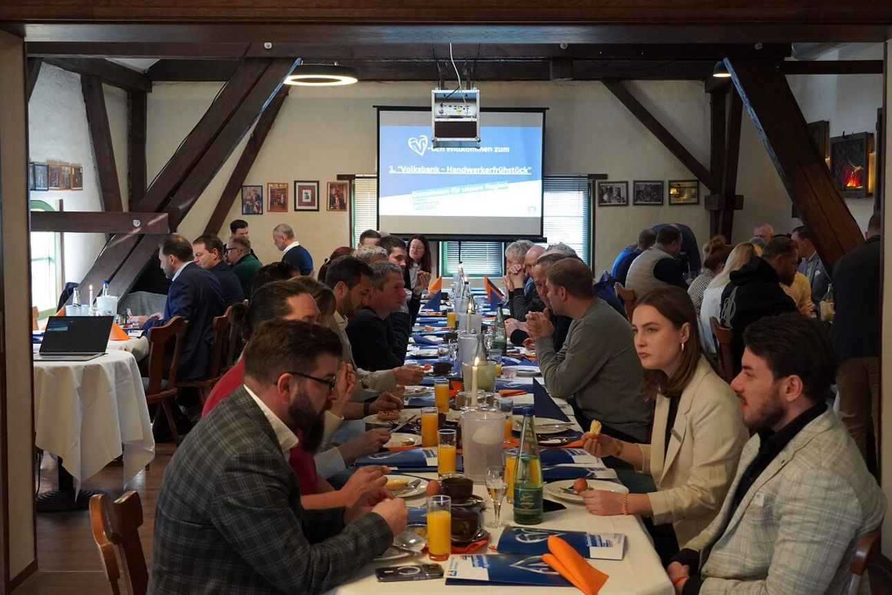 Mehrere gutgelaunte Menschen beim Händlerfrühstück 