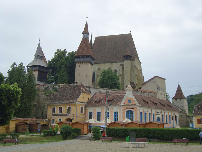 Ein malerischer Platz, eingerahmt von historischen Gebäuden mit Terrakottadächern und spitzen Türmen