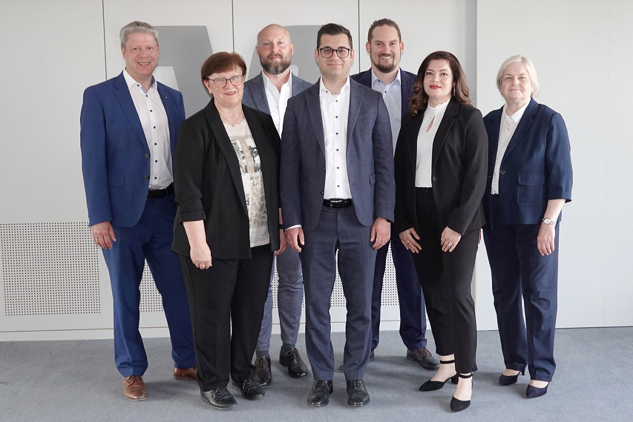 Gruppe Menschen in Anzügen vor hellem Hintergrund