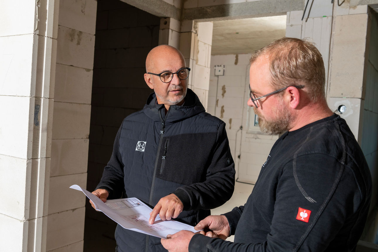 Zwei Männer schauen sich einen Bauplan an.