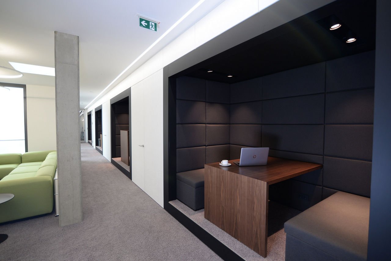 Rechts eine Sitznische mit Tisch und Bänken, ein langer Gang, der an mehreren Nischen vorbei führt.