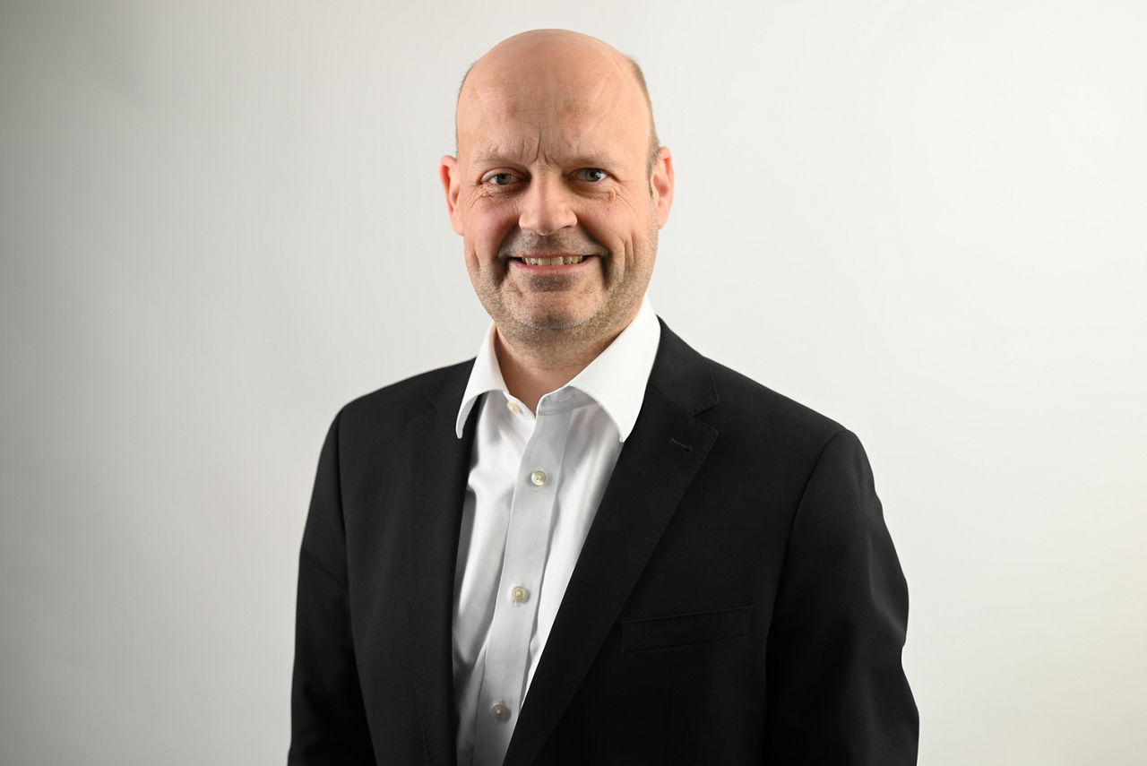 Firmenkunden Eric Brühne vor grauem Hintergrund