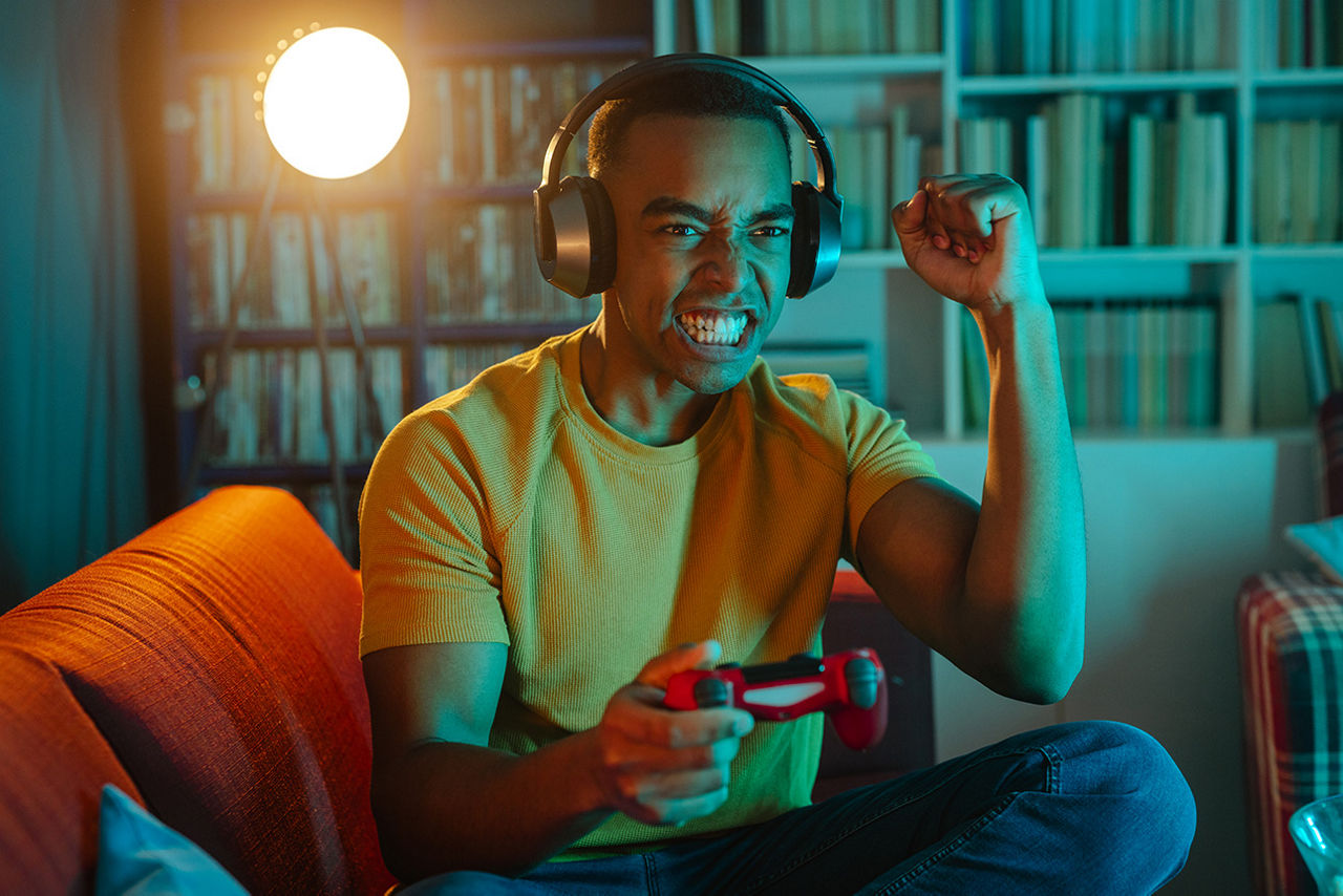 Junger Mann mit Kopfhörern beim Online-Spiel