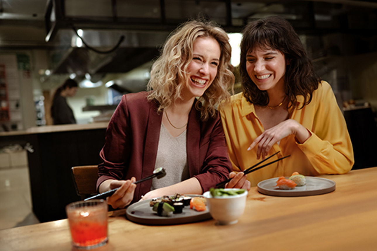 Zwei Freundinnen essen Sushi in einem Restaurant