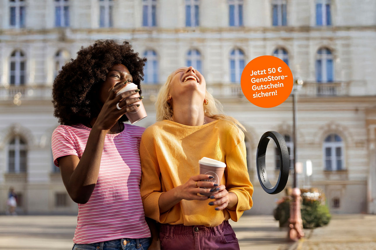 Zwei Frauen trinken lachend Kaffe. Schriftzug "Jetzt 50€ GenoStore-Guschein sichern"
